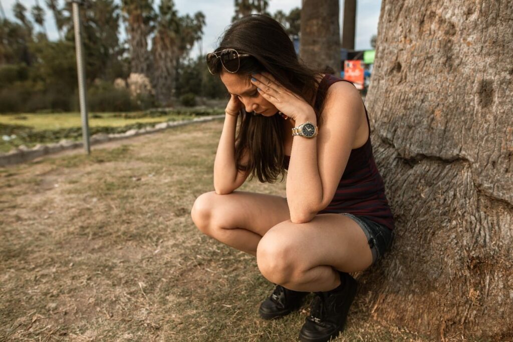 femme contre arbre tient tête ressent stress et anxiété